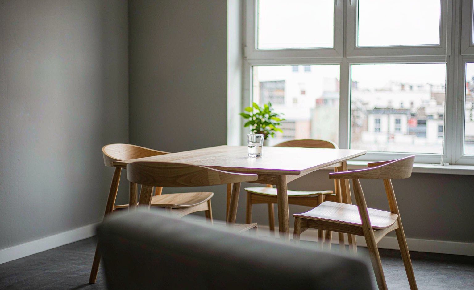 Helles Besprechungszimmer mit Holztisch am Fenster